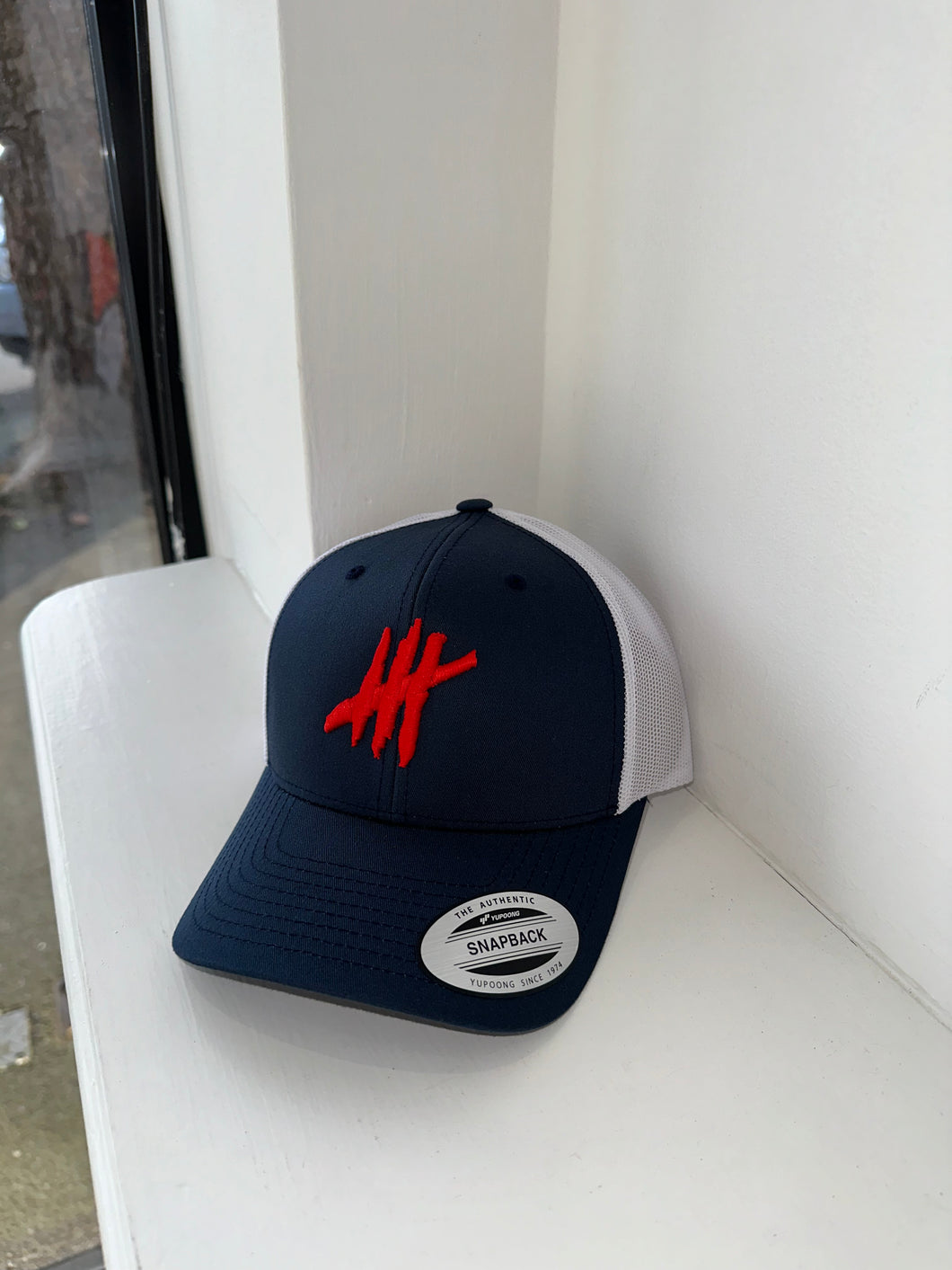 Navy & white trucker cap with white & red logo