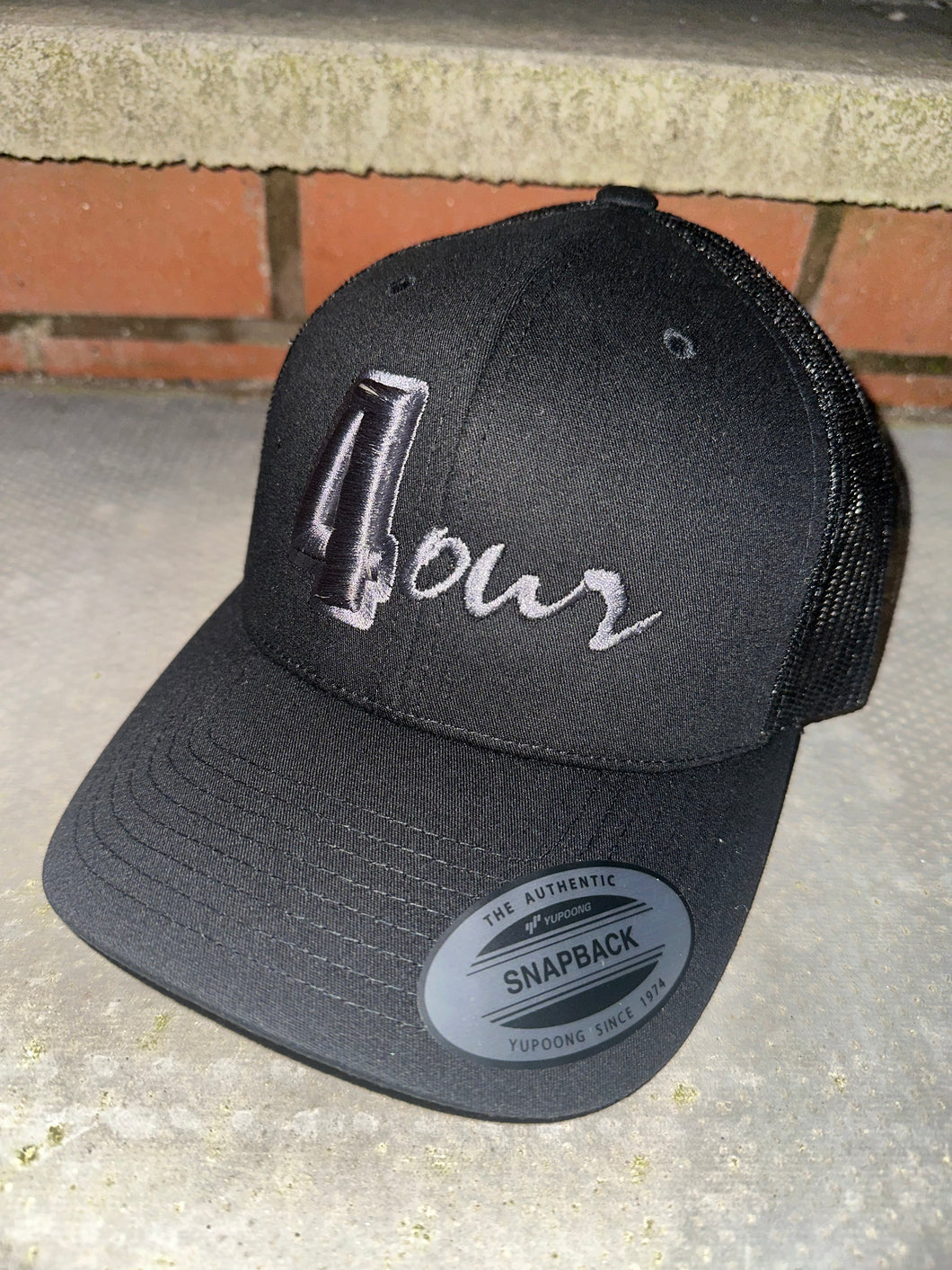 Black trucker cap with grey logo