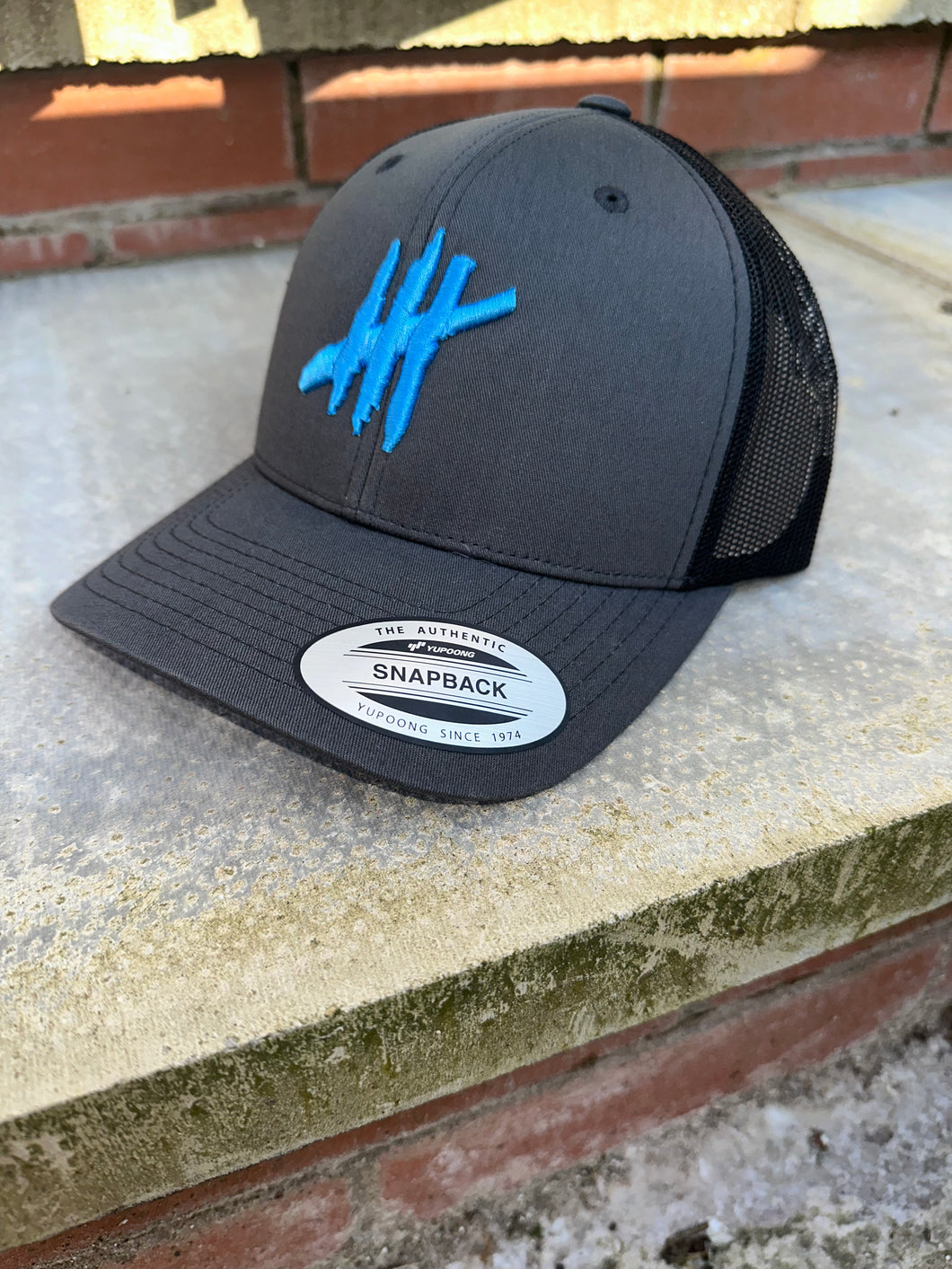 Grey & black trucker cap with light blue logo