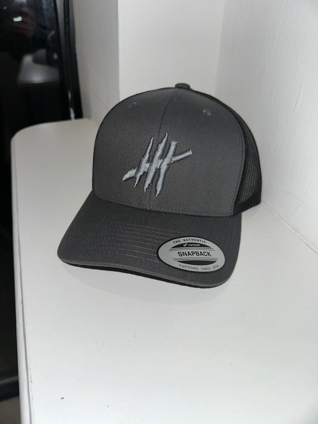 Grey & black trucker cap with grey logo