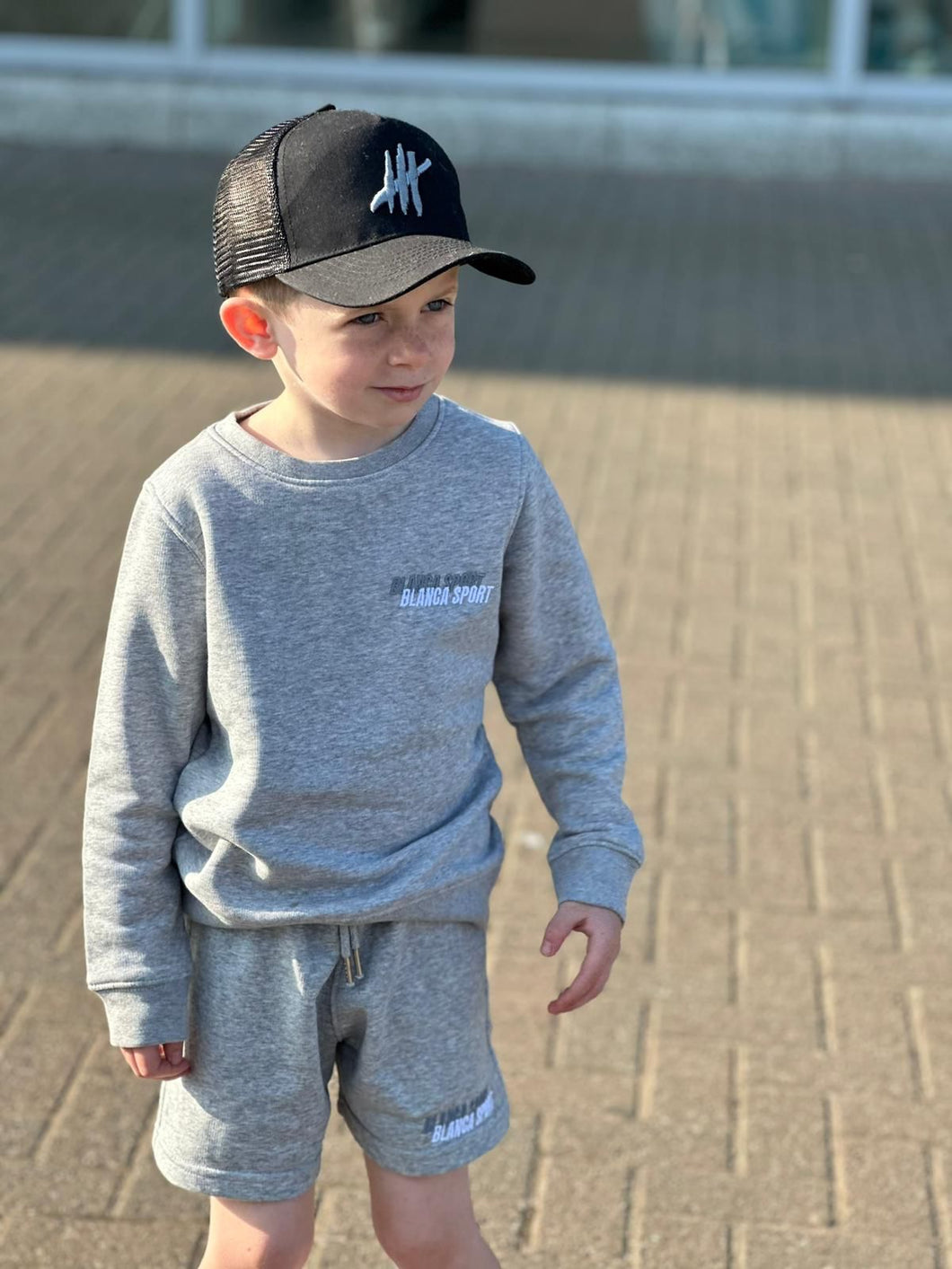 Black trucker youths cap with grey logo