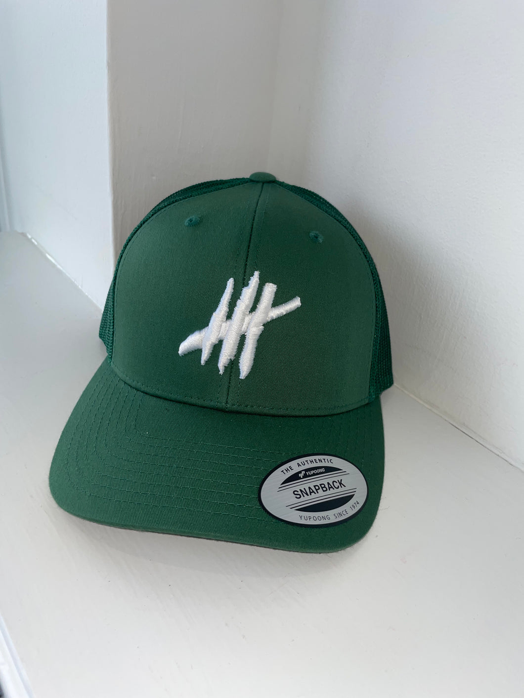 Green trucker cap with white logo