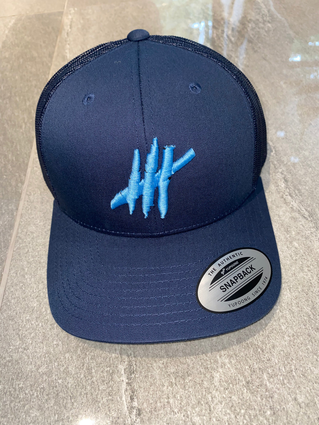 Navy trucker cap with light blue logo